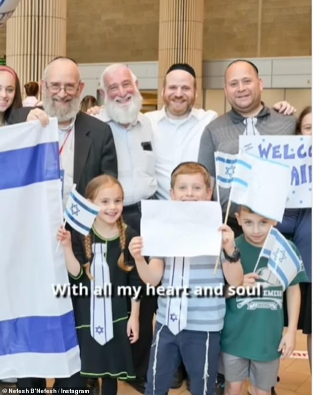 Groups gather holding Israeli flags and smiling as they return to their homeland