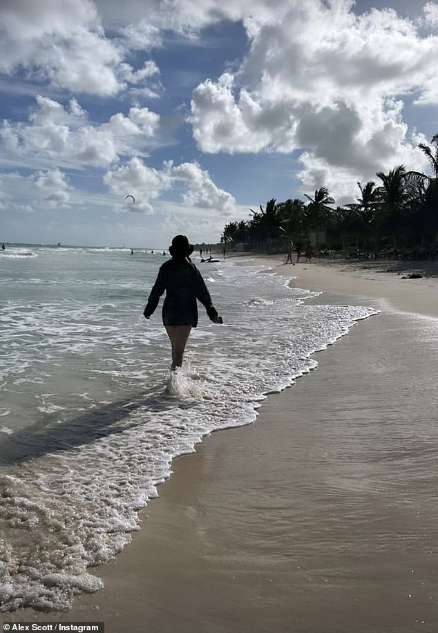 Sports commentator Alex, 39, showed off her slim legs as she wore a black robe hanging over her shoulder as she walked on the beach