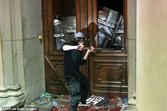 In the photo: A protester uses a metal object against police officers at the entrance to the Belgrade City Hall