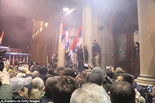 Pictured: Protesters gathered outside Belgrade City Hall after the main opposition Serbia Against Violence alliance said it had been robbed of a victory and said it would not recognize the election outcome