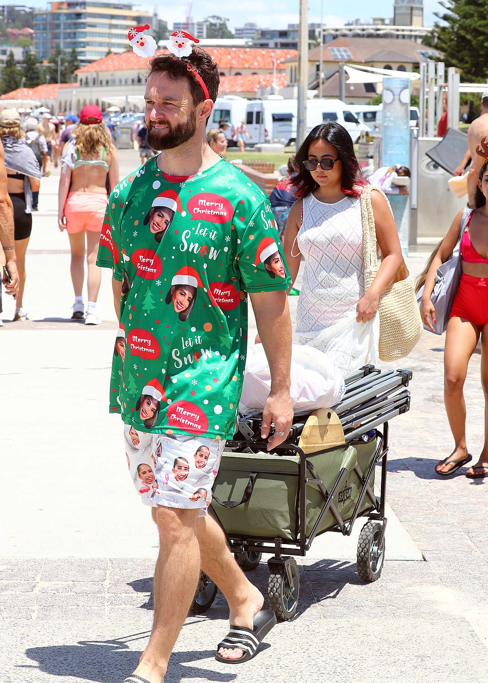 One man is seen wearing a Christmas outfit with a Santa headband