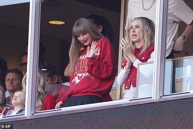 Swift waves with her new girlfriend Brittany Mahomes from a suite at Arrowhead Stadium