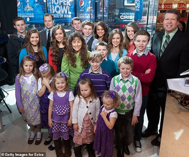 Famous family: Michelle and Jim Bob pictured with their large brood in March 2014