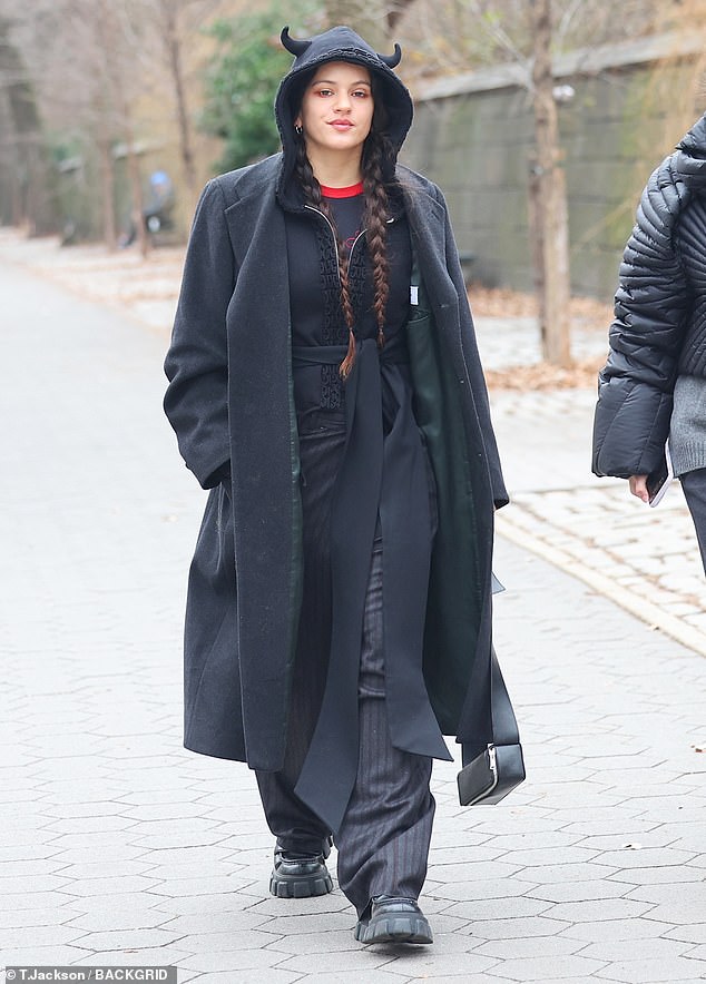 She paired the ensemble with a black coat that she unbuttoned to help her stay warm in the cold weather