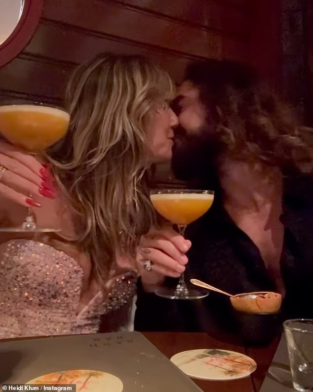 The couple shared a sweet kiss for a photo while sipping a cocktail on Christmas Day