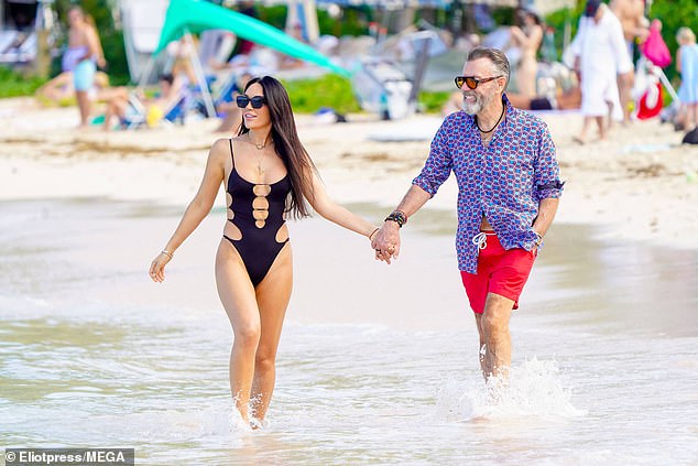 Nigora looked stunning in a black cut-out swimsuit as she clung to Duncan as she took a dip