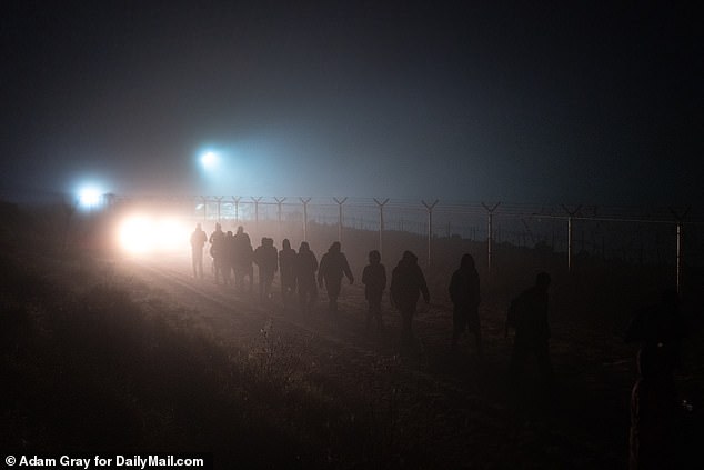 Migrants walk to a processing center escorted by US authorities after crossing the border into Eagle Pass, Texas, United States.  December 26, 2023. Most of the group came from Venezuela