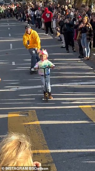 A child was seen going down the hill on her scooter while wearing a unicorn helmet