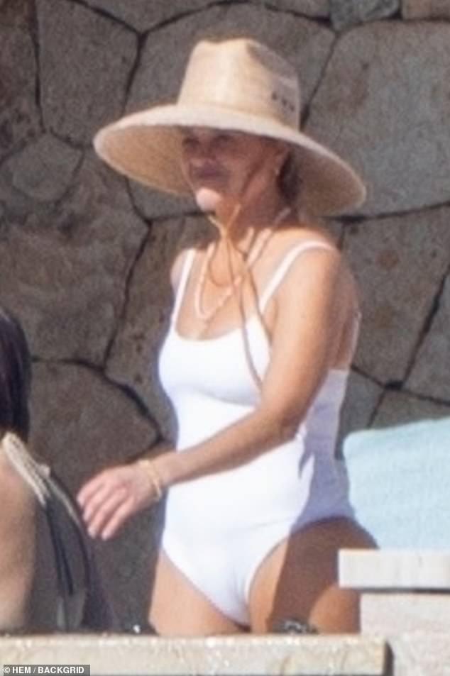 Wearing a chic white swimsuit and a wide-brimmed hat, the star looked fantastic