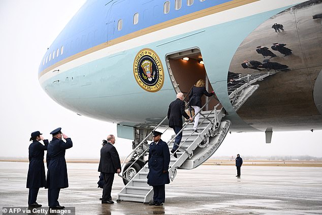 Joe and Jill Biden board the smaller steps of Air Force One in the rain as they began their trip to the Caribbean