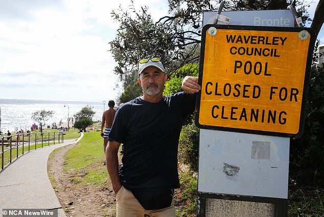 Local Bronte resident Marian Riabic poses next to the council sign and warns that the Waverly pool will be closed on December 27 for cleaning