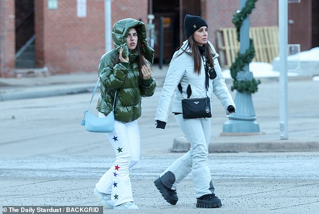 Wearing a white padded jacket and matching trousers, she added a black beanie, a designer crossbody bag and a pair of chunky heeled boots to the mix.