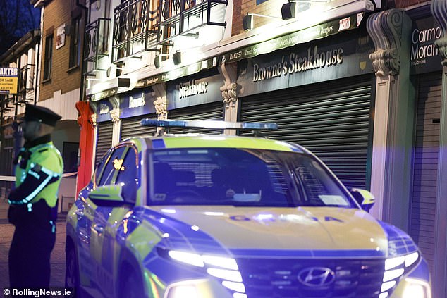 Police patrol the street outside the steakhouse where one man was killed and another shot