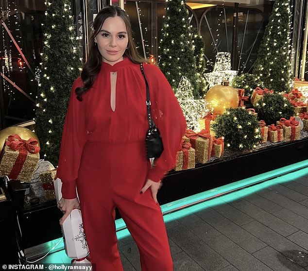 She also carried a chic black bag and posed outside the hotel with a huge Christmas cracker in her hand