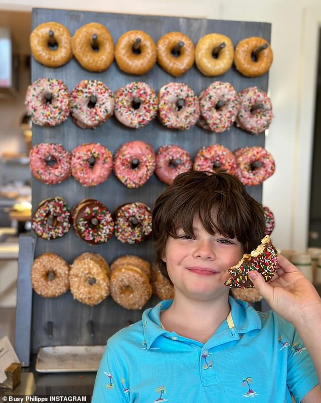 She also snapped a photo of her cousin grinning widely as he posed in front of a donut display on the wall.