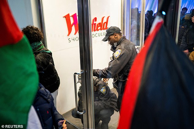 New York police officers block an entrance to the World Trade Center as pro-Palestinian protesters march demanding a ceasefire