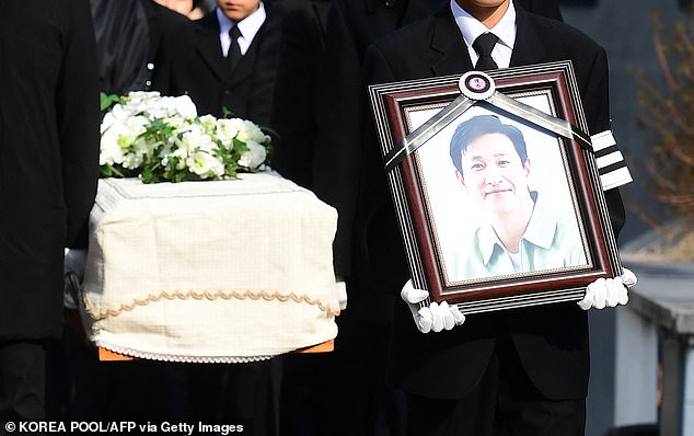 Mourners carry a portrait and the coffin containing the late South Korean actor Lee