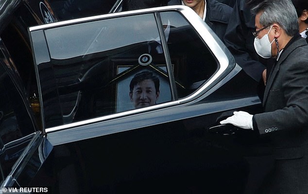 A portrait of the late actor can be seen through the window of a car during his funeral