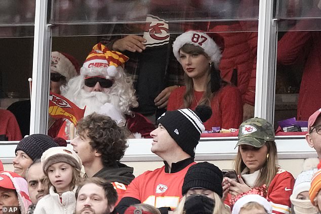 Taylor sat next to a Santa Claus - presumably brother Austin - who was wearing a Chiefs Santa hat