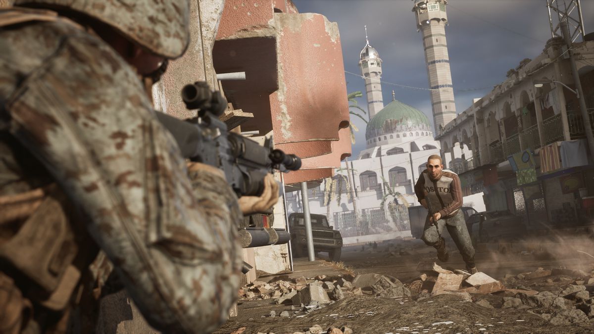 a screenshot from Six Days in Fallujah: An armed man runs through the streets of virtual Fallujah.  A Marine is pointing in the foreground.  In the background the minarets of a beautiful mosque.