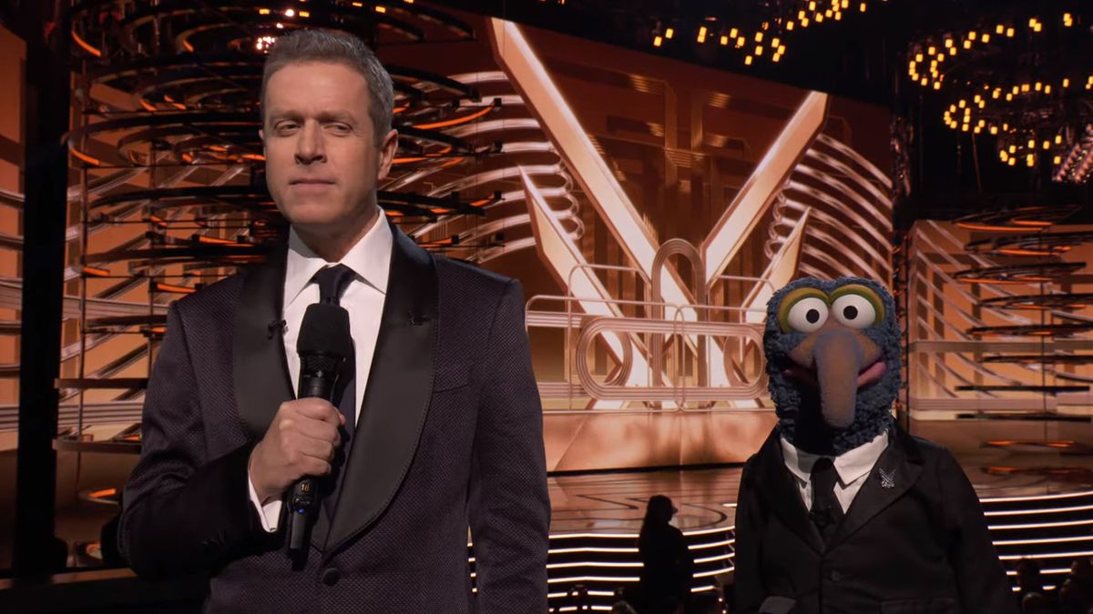 Game Awards host Geoff Keighley stands next to Gonzo from the Muppets, both dressed in similar suits.