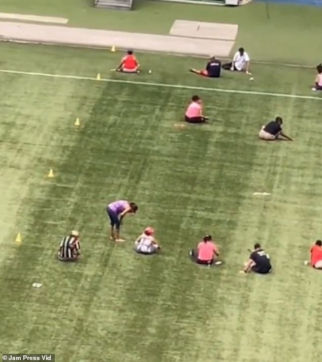 They were filmed laboriously picking bracelet beads from the grass on the field