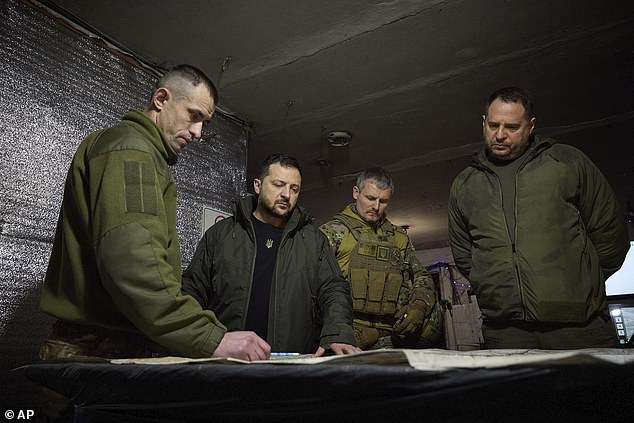 Ukrainian President Volodymyr Zelensky, 2nd from left, looks at a map during his visit to the Ukrainian 110th Mechanized Brigade in Avdiivka, the site of heavy fighting with Russian forces in the Donetsk region, Ukraine, on Friday