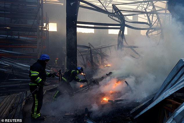 Firefighters work at a site of a warehouse that was heavily damaged in a Russian missile attack in Kiev
