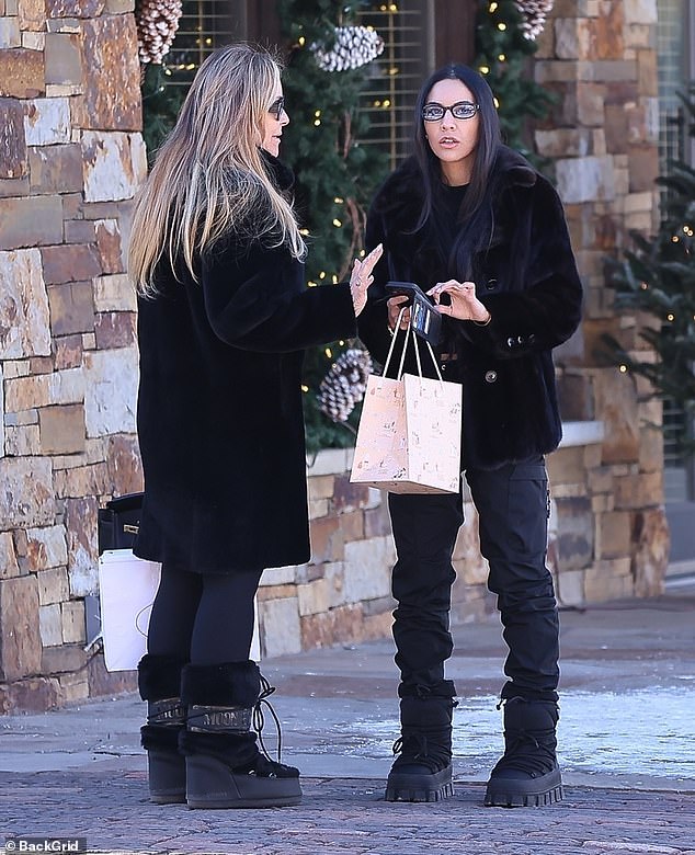 She completed the chic look with a set of designer sunglasses and black Prada nylon gabardine après ski boots