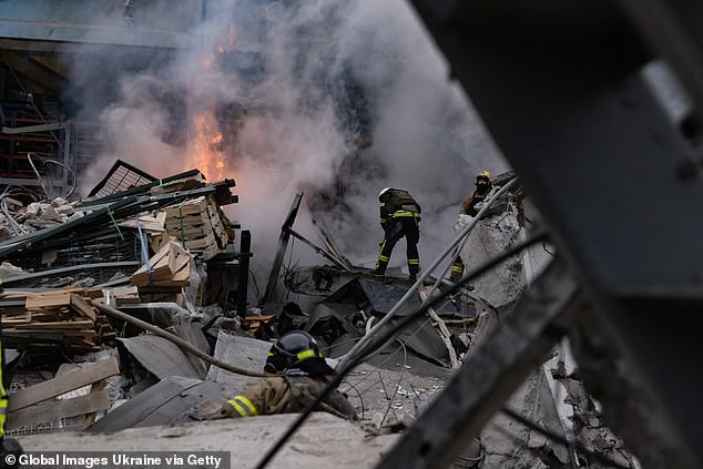 Firefighters extinguish a fire in a damaged business after a Russian missile attack on December 29, 2023 in Kharkiv, Ukraine