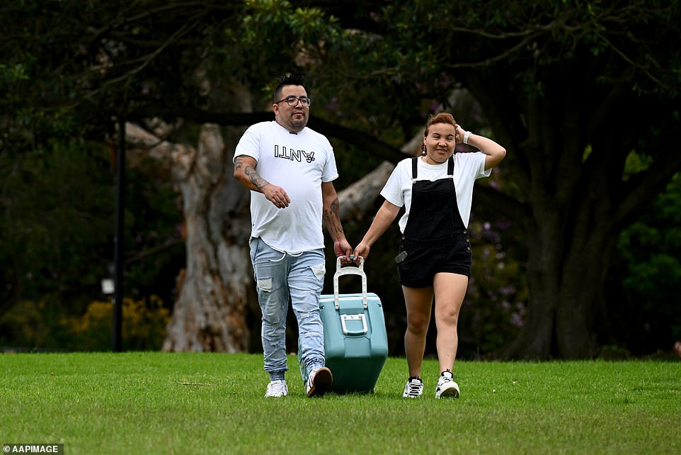 A couple tows an esky as they prepare to camp all day to watch the 2024 fireworks