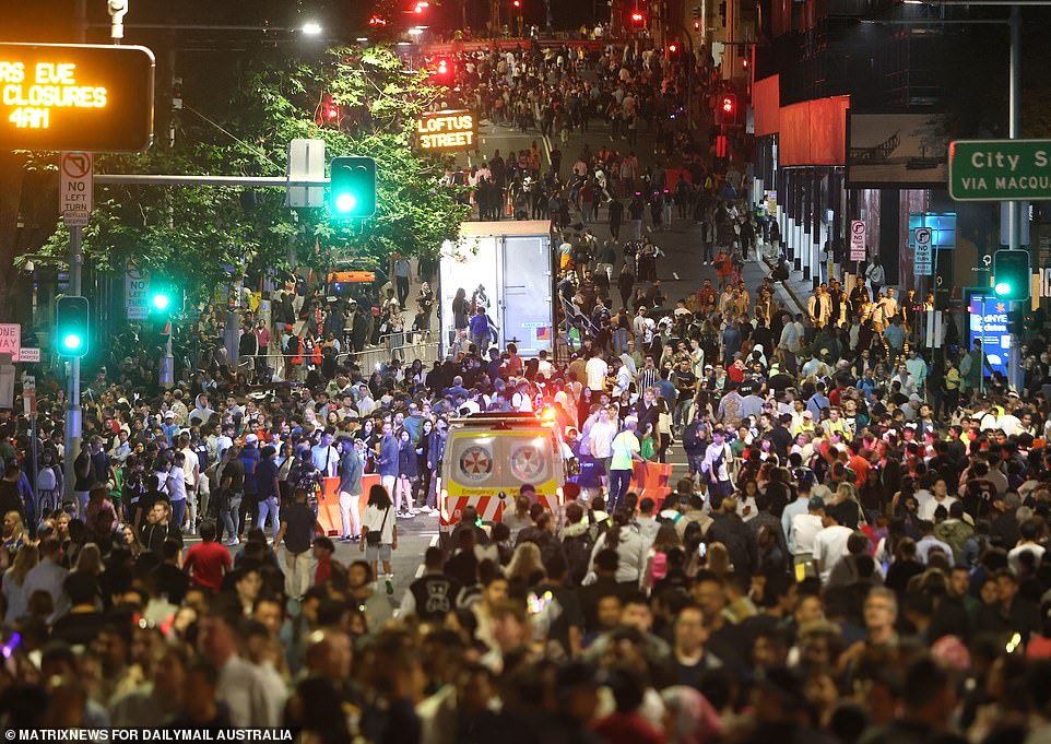 An emergency vehicle tries to make its way through the busy streets