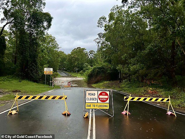 Particularly intense rainfall of up to 250mm over six hours could lead to dangerous and life-threatening flash flooding, the agency warned.  A road closure in Gold Coast is pictured