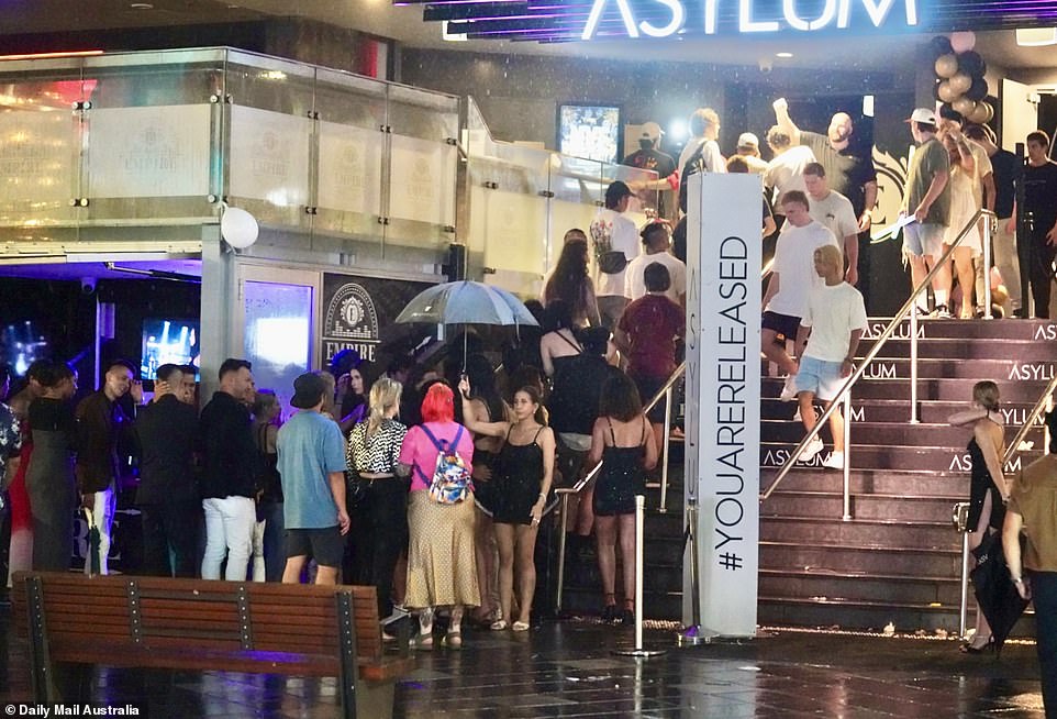 Only one reveler remembered to grab an umbrella, while dozens of people lined up outside a venue