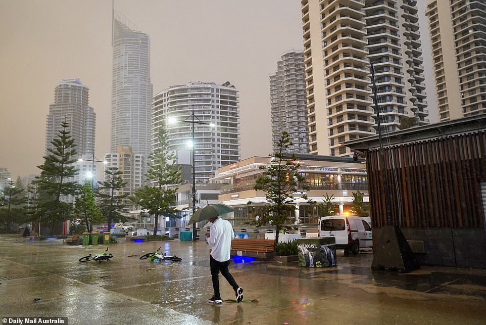 A man is seen walking home in the rain as the sun rises Monday morning