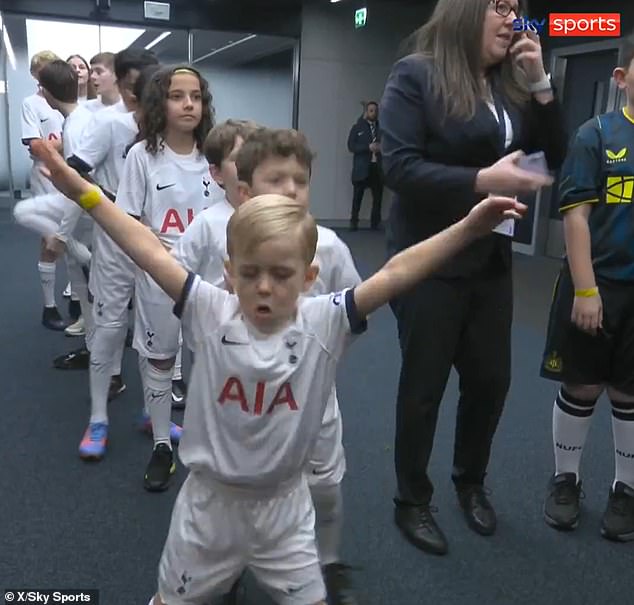 This is the moment a young Spurs mascot (pictured centre) was passionately preparing for a football match while inside the football tunnel of the Tottenham Hotspur stadium in north London.