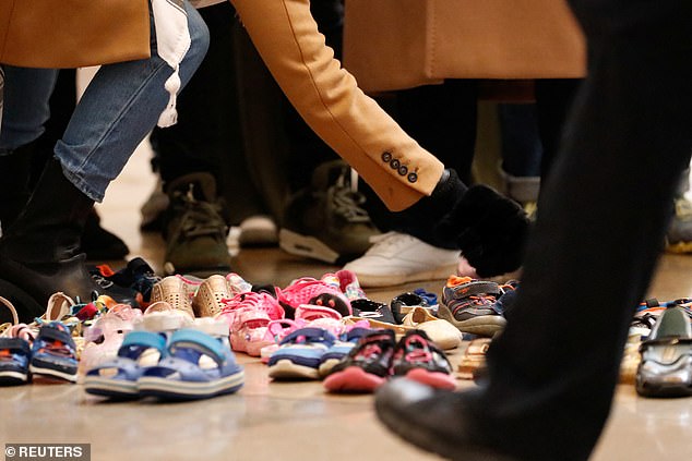 A protester places children's shoes on the floor to draw attention to the toll of Israel's bombing of Gaza on children, during a protest in the U.S. Capitol rotunda