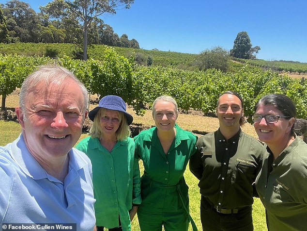 Anthony Albanese (left) and partner Jodie (centre) posed for photos with Cullens Wines staff in the vineyard before tasting an expensive red wine worth $500