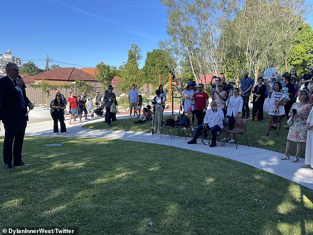 The lone protester was seen holding a baby and defiantly holding up a sign as Prime Minister Anthony Albanese addressed a small crown in Sydney's west