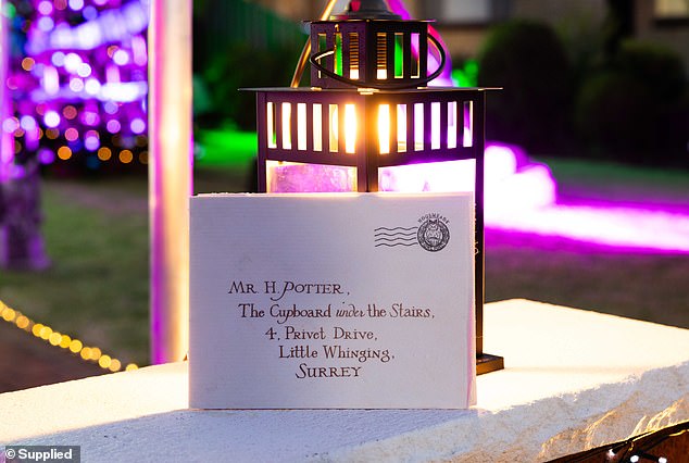 The invitation letter Harry received before he went to school lies against a lamp