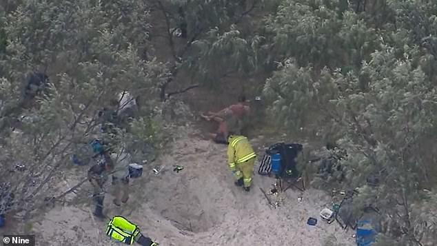 Emergency services are pictured at the site where Taylor was buried under the sand