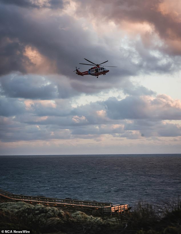 A rescue helicopter was deployed to the scene (pictured) to scour the beach and coastline in the ongoing search for the 14-year-old boy.