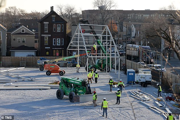 Workers set up a tent frame as they begin construction on Chicago's first government-run migrant tent camp in the Brighton Park neighborhood