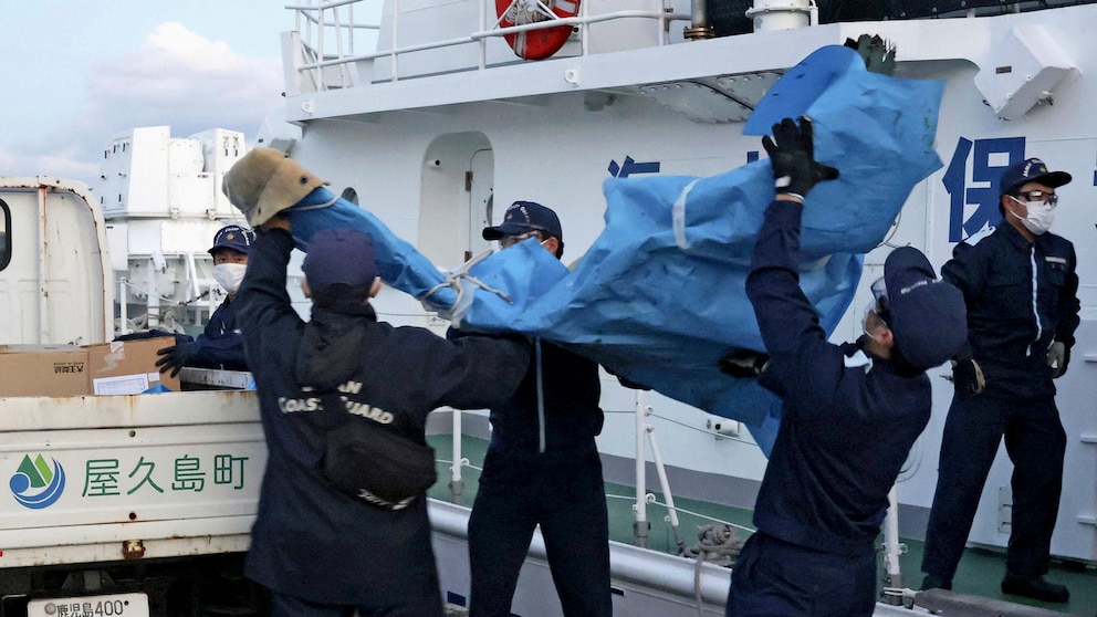 Japan Coast Guard members carry debris, believed to be from the crashed US military Osprey aircraft, to a port in Yakushima, Kagoshima Prefecture, southern Japan, Monday, December 4, 2023. Japanese and US military divers saw what they say is the remains may be of a U.S. Air Force Osprey plane that crashed off the coast of southwestern Japan last week, and some of its six crew members still missing, local media reported Monday.  (Kyodo News via AP)