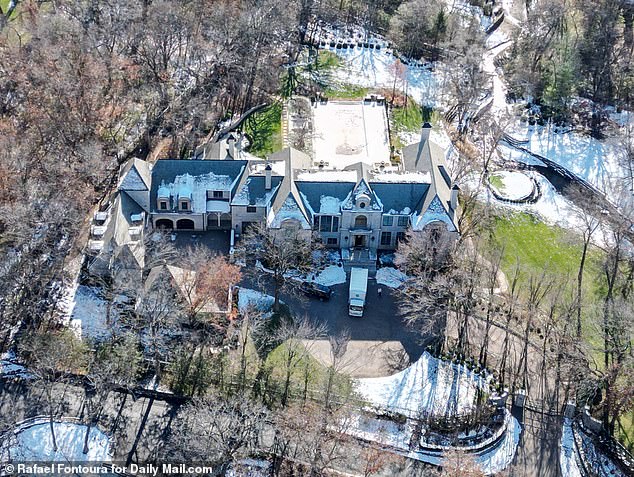 Pictured: Travis Kelce's new home in Kansas City.  Furniture and other items were seen being carried by staff to the main entrance of the snow-covered $6 million mansion when another vehicle drove into the six-car garage.