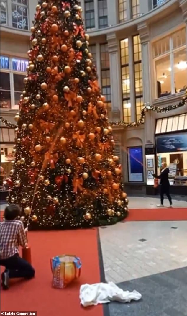 In a video posted to X last week, two protesters are seen spraying a Christmas tree with orange paint from fire extinguishers, while a third unfurled a banner nearby.