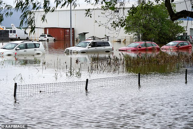 Submerged vehicles are seen in floodwaters in the Cairns suburb of Aeroglen, Monday, December 18