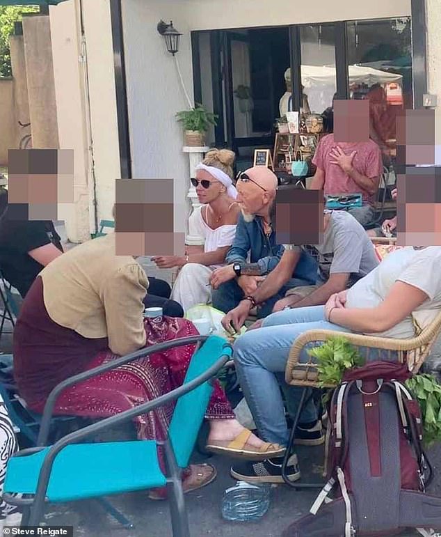 Fugitive mother Melanie Batty sits next to her father David Batty (in denim shirt) and her son Alex Batty (in black T-shirt) at the Esperaza market in June 2023