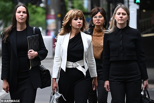 Emma Walters (white coat) arrives at the Melbourne Magistrates Court on Friday - where a magistrate found she threatened to kill John Setka