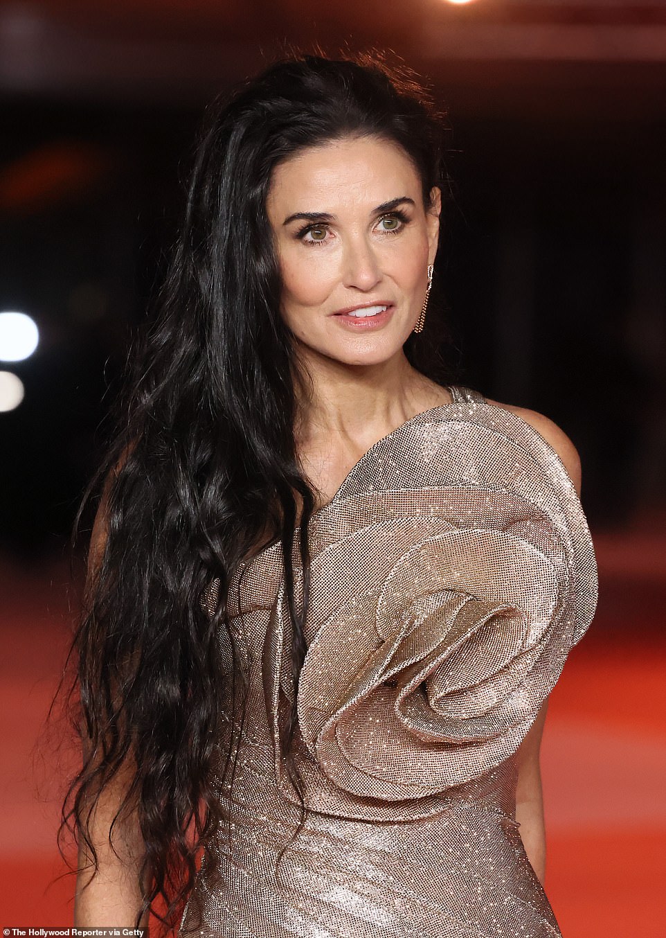 The 61-year-old actress had her long black hair swept to one side and down around her waist and accessorized with dangling earrings, bracelets and rings